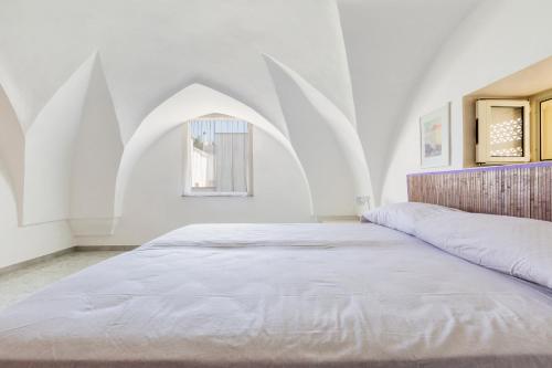 ein Schlafzimmer mit einem großen Bett und einem Bogenfenster in der Unterkunft Villino Salsedine by BarbarHouse in Nardò
