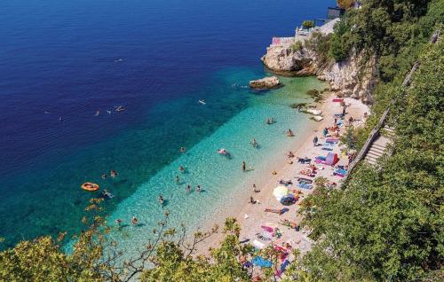 a group of people on a beach in the water at Apartments Chiara mit Meerblick und Pool und Jacuzzi in Lovran