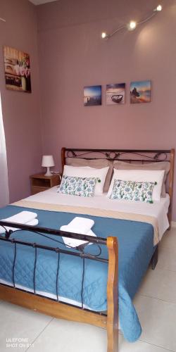 a bedroom with a large bed with blue sheets and pillows at Iris's apartment central with parking in Argostoli
