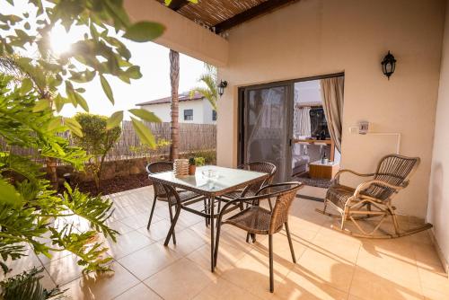 a patio with a table and chairs on a patio at פרדייז ברמה in Had Nes