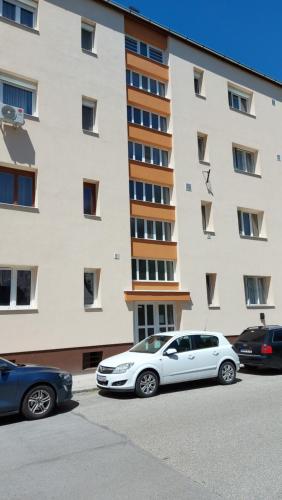 a white car parked in front of a building at Ancsi Apartmant Kecskemét in Kecskemét