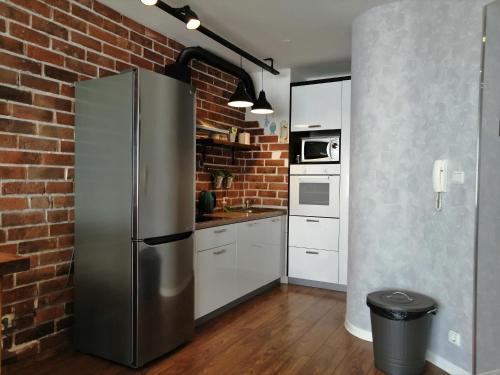 a stainless steel refrigerator in a kitchen with a brick wall at Apartment Radosevac Beach in Split