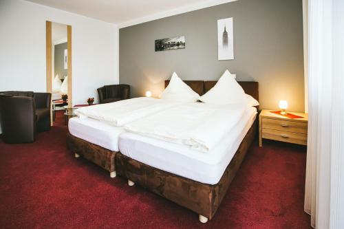 1 dormitorio con 1 cama grande con sábanas blancas en Schultes Landhaus, en Delbrück