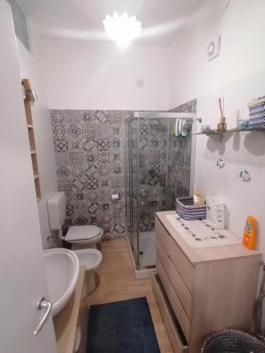 a bathroom with a shower and a toilet and a sink at Super terrazzo panoramico in Letojanni