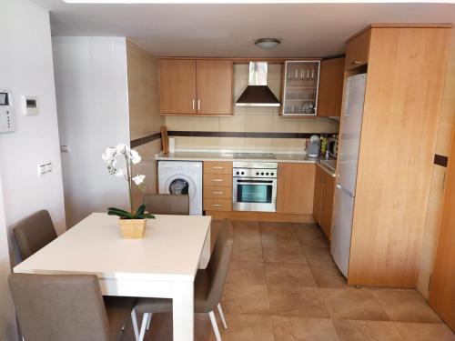 a kitchen with a table and a white table and chairs at Panorámica Golfmar c/ Generalitat in Sant Jordi