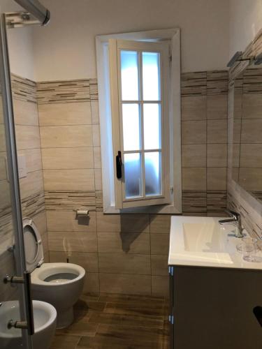 bagno con servizi igienici, lavandino e finestra di Villa Cataleya a Praia a Mare