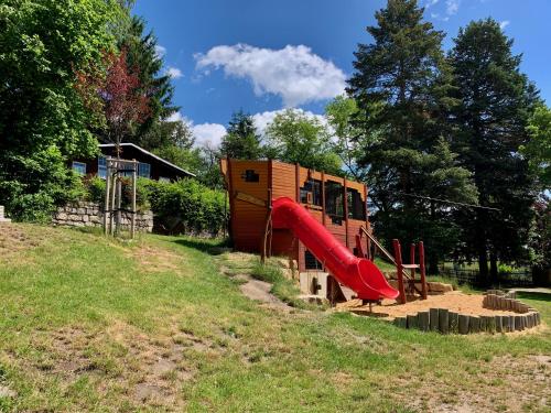 un parque infantil con un tobogán rojo en un campo en Villa Frieden Hotel & Seminarhaus, en Bad Blankenburg