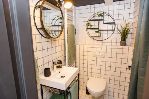 a bathroom with a sink and a toilet and mirrors at UrbanJungle - Your trendy loft in central Budapest in Budapest