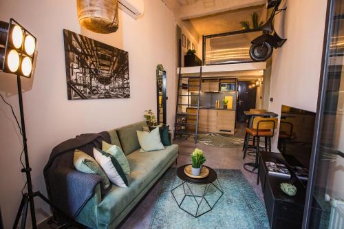 a living room with a couch and a table at UrbanJungle - Your trendy loft in central Budapest in Budapest