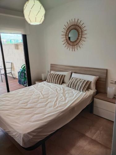 a bed in a bedroom with a mirror on the wall at Panorámica Golfmar c/ Generalitat in Sant Jordi