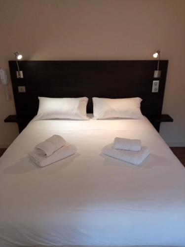 a large white bed with two white towels on it at Le Prieuré in Saint-Dalmas-de-Tende