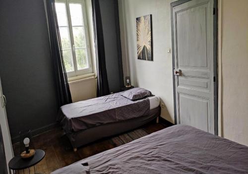 a bedroom with two beds and a window at CAP NATURE - T4 et T3 en Périgord vert - horaires adaptables- Idéal PROS et GROUPES in Champniers-et-Reillac
