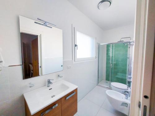 La salle de bains est pourvue d'un lavabo, de toilettes et d'un miroir. dans l'établissement Mareluce B&B, à Porto Cesareo