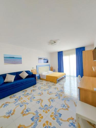 a living room with a blue couch and a bed at B&B Mareluce in Porto Cesareo