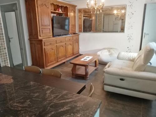 Una sala de estar con un sofá blanco y una mesa. en villa Natacha, en Villeparisis