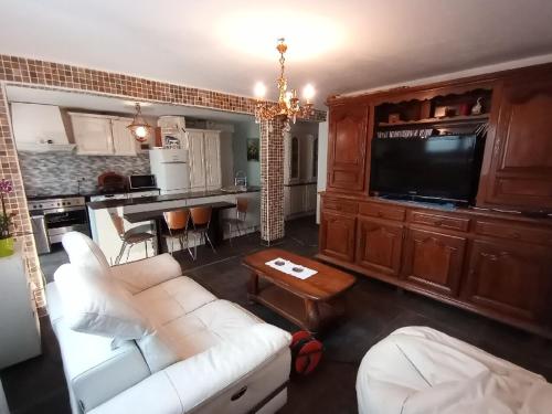 un salon avec un canapé blanc et une cuisine dans l'établissement villa Natacha, à Villeparisis