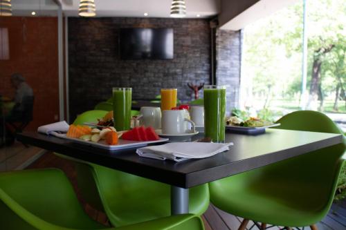 a table with a tray of fruit on it at Hotel Diana del Bosque by DOT Urban in Morelia