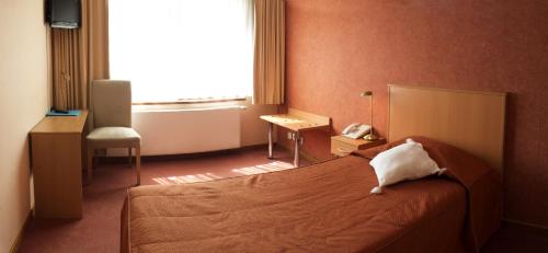 a bedroom with a bed and a telephone and a window at Le Relais Du Marquis in Ittre