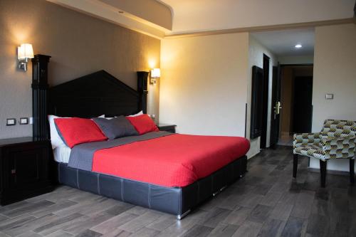 a bedroom with a large bed and a chair at Hotel Diana del Bosque by DOT Urban in Morelia