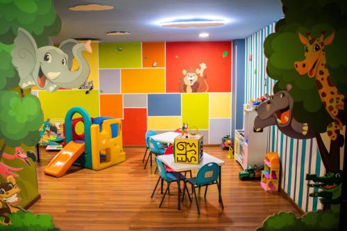 una sala de juegos para niños con mesa y sillas en Hotel Diana del Bosque by DOT Urban, en Morelia
