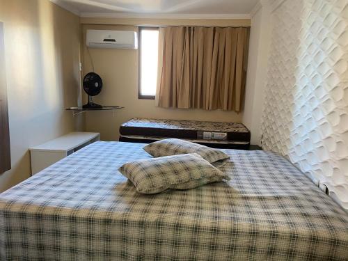 1 dormitorio con 1 cama con 2 almohadas en Porto de Iracema 1807, en Fortaleza