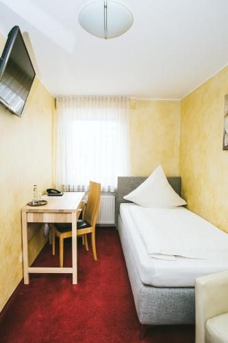 a bedroom with a bed and a desk and a table at Schultes Landhaus in Delbrück