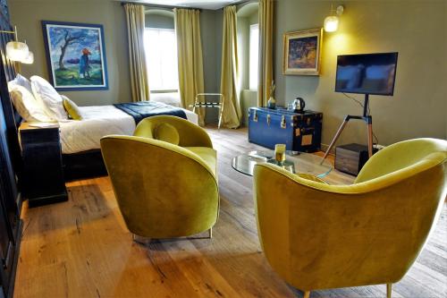 a hotel room with a bed and chairs and a television at A Villa di Rutali in Rutali