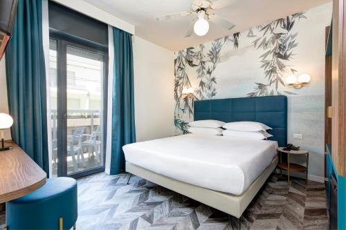 a bedroom with a bed and a large window at Hotel Byron Bellavista in Lido di Jesolo