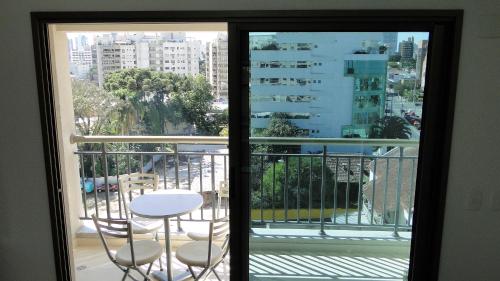 Habitación con vistas a un balcón con mesa y sillas. en Requinte e privacidade em bairro nobre de Curitiba en Curitiba