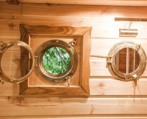 a wooden wall with two mirrors and a window at Parthénope - Les Cabanes du Chêne Rouvre in Saint Die