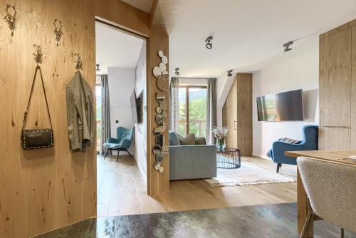 a living room with wooden walls and blue chairs at Tatra Resort & SPA in Kościelisko