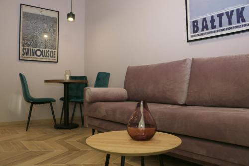 a living room with a brown couch and a table at Apartament Matejki 17 - Insel Apartamenty in Świnoujście