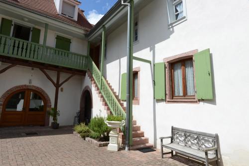 un banc installé à l'extérieur d'un bâtiment avec terrasse couverte dans l'établissement La Maison Oberlin, à Horbourg-Wihr