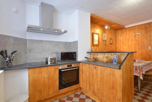 a kitchen with wooden cabinets and a black counter top at La Maison Oberlin in Horbourg