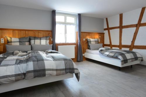 2 camas num quarto com paredes e pisos em madeira em La Maison Oberlin em Horbourg
