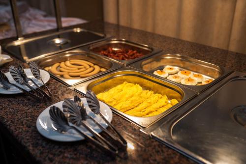 a buffet with trays of food on a counter at Hotel Mara in Sinaia