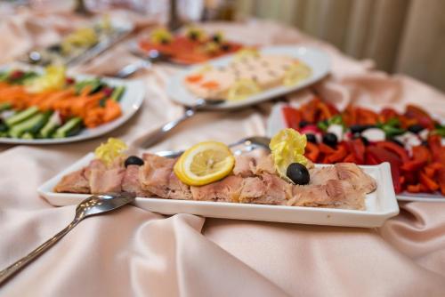 a table topped with plates of food on a table at Hotel Mara in Sinaia