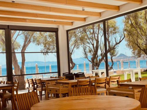 a restaurant with tables and chairs and a view of the water at Regia Mare Beach Hotel & Spa Bodrum in Ortakent