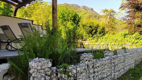 a garden with a stone wall and plants at Ferienwohnung Lattenberg in Bayerisch Gmain