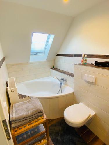 a bathroom with a white tub and a toilet at HaRe Ferienwohnungen in Langeneß