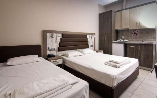 1 dormitorio con 2 camas y cocina en SUNSET HOTEL en Néos Marmarás