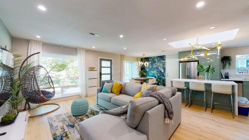 a living room with a couch and a kitchen at @ Marbella Lane - SJ Designer Home 3BR Ldry+P in San Jose
