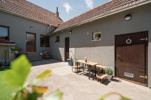 a patio with a wooden table and chairs next to a house at Ubytování 121 - Hlohovec in Hlohovec