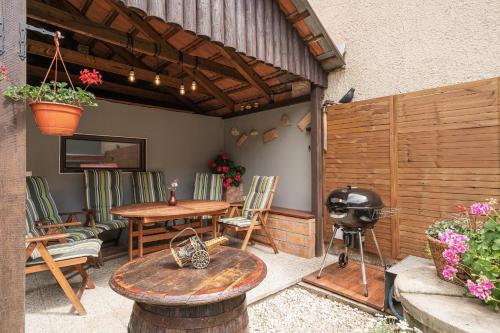 a patio with a table and chairs and a grill at Ubytování 121 - Hlohovec in Hlohovec