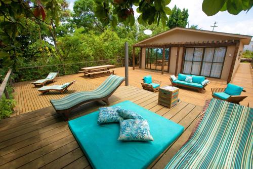 a deck with a bench and chairs and a table at Villa Cordel in Fernando de Noronha