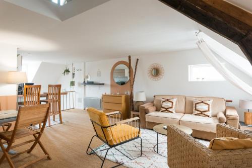 ein Wohnzimmer mit einem Sofa, einem Tisch und Stühlen in der Unterkunft Le Teck in Deauville