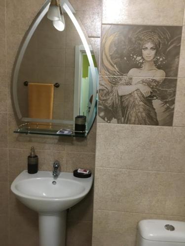 un baño con lavabo y una foto de una mujer en Sasso-апартамент 4, Sasso-студио 5 en Pleven