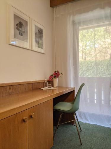 a bathroom with a desk and a chair and a window at Hotel Schönbrunn in Merano