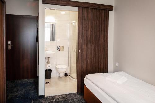 a bathroom with a bed and a shower and a toilet at Dom Wczasowy Kliper in Niechorze