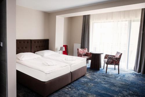 a bedroom with a bed and a table and chairs at Dom Wczasowy Kliper in Niechorze